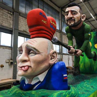 Ein Motivwagen zum Thema Ukraine-Krieg steht beim Richtfest des Kölner Rosenmontagszuges in der Wagenhalle. Eine Selenskyi-Figur haut mit einem „Herzhammer“ auf eine Putin-Figur.