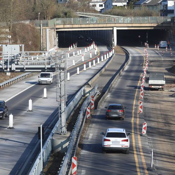 Eine Großbaustelle auf einer vierspurigen Straße, im Hintergrund die Einfahrt in einen Tunnel.
