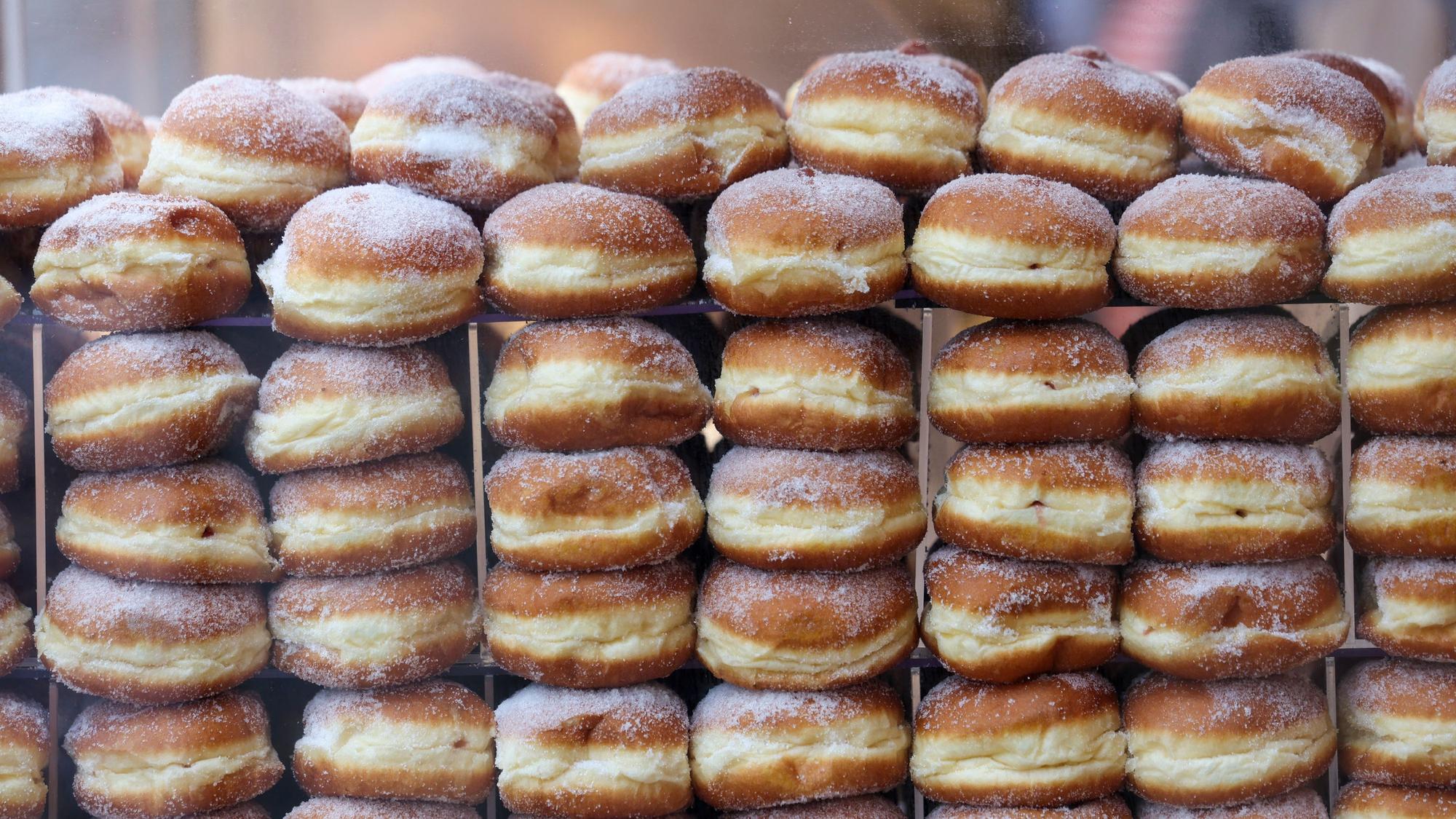 27.02.2025, Nordrhein-Westfalen, Köln: Berliner liegen aufgestapelt in einer Bäckerei. Am Donnerstag beginnt mit der Weiberfastnacht die Karnevalssession 2025. Foto: Thomas Banneyer/dpa +++ dpa-Bildfunk +++
