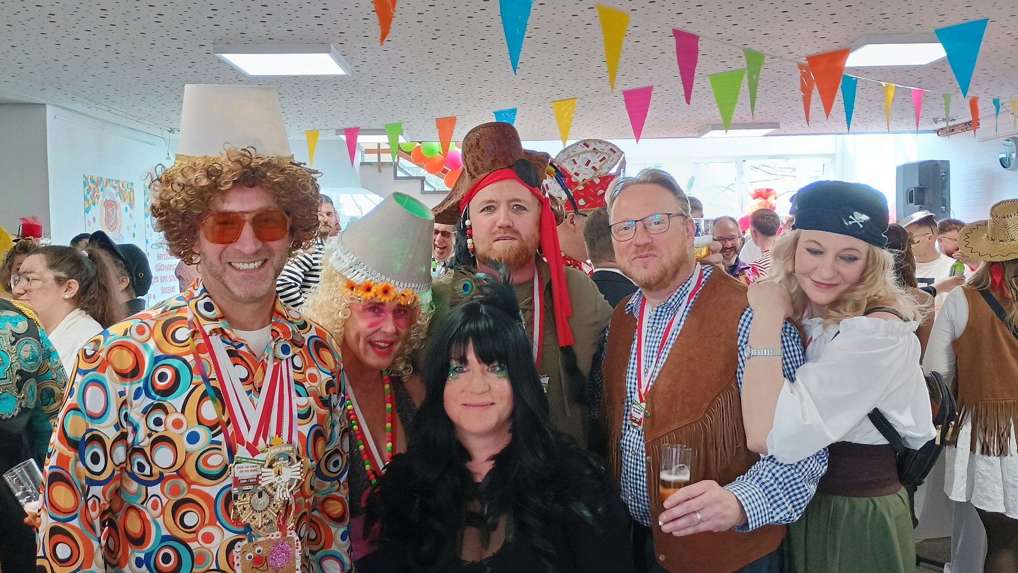 Heller trägt eine Lampe auf dem Kopf und ein buntes Hemd. Er trägt mehrere Orden um den Hals.