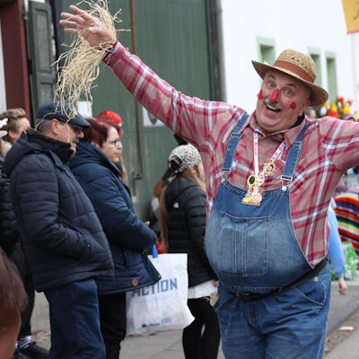 Als Vogelscheuche verkleidet und mit ausgebreiteten Armen geht ein Zugteilnehmer durch Dom-Esch.