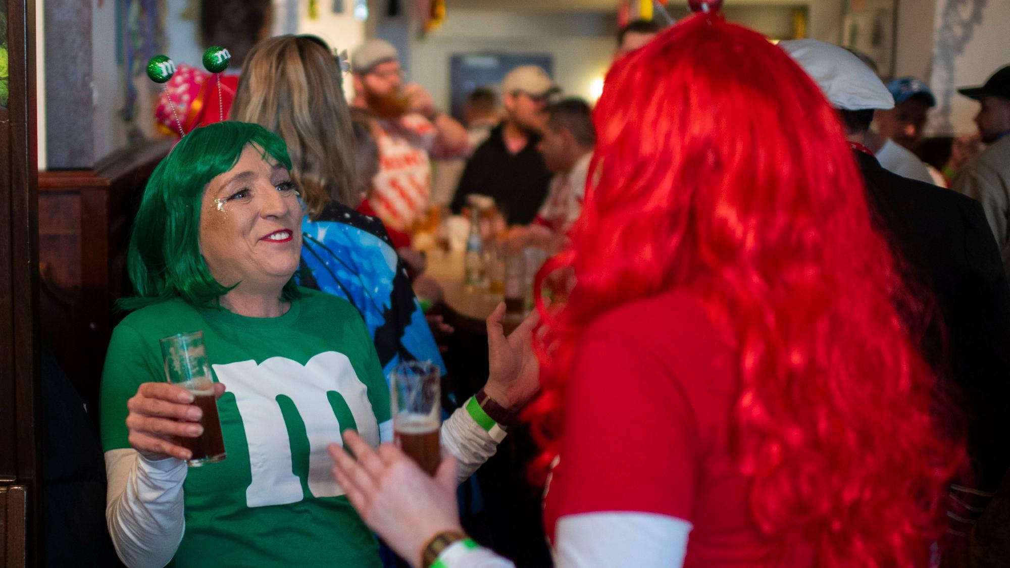 Zwei weibliche Jecken, die am M&M verkleidet sind, tanzen in der Kneipe.