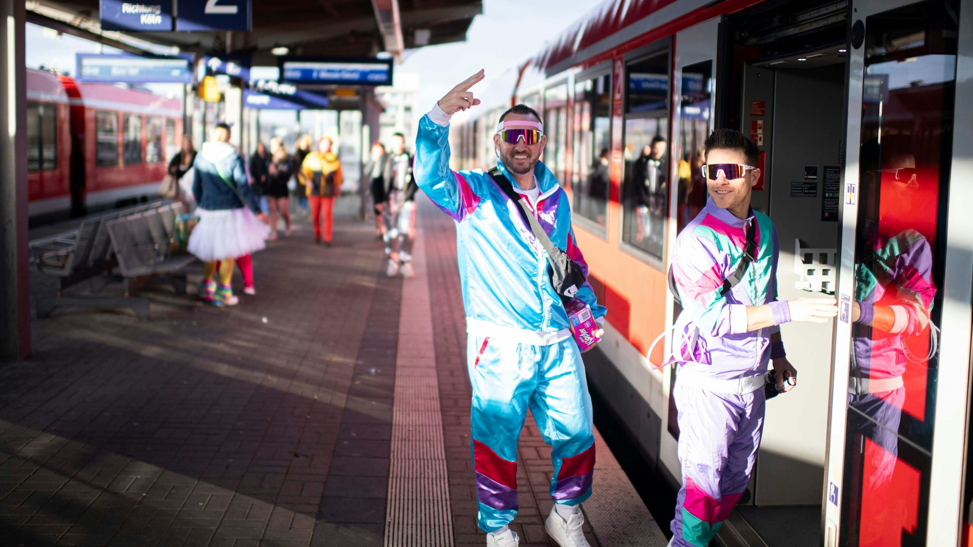 Das Bild zeigt zwei kostümierte Männer, die in den Zug einsteigen.