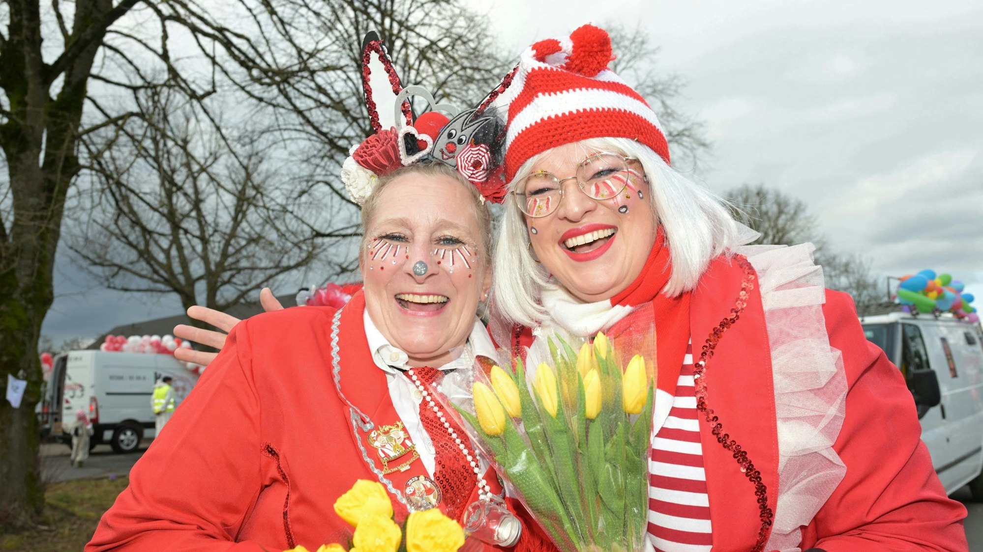 Zwei Frauen im rot-weißen Karnevalskostüm lachen in die Kamera.