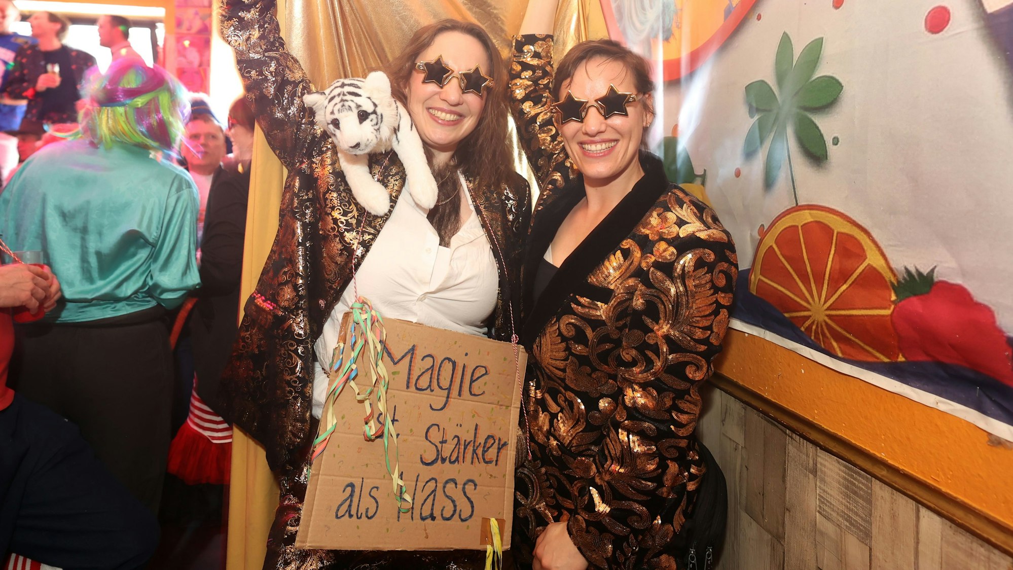 Julia Siemoneit und Karla Verlinden halten ein Schild hoch: „Magie ist stärker als Hass“