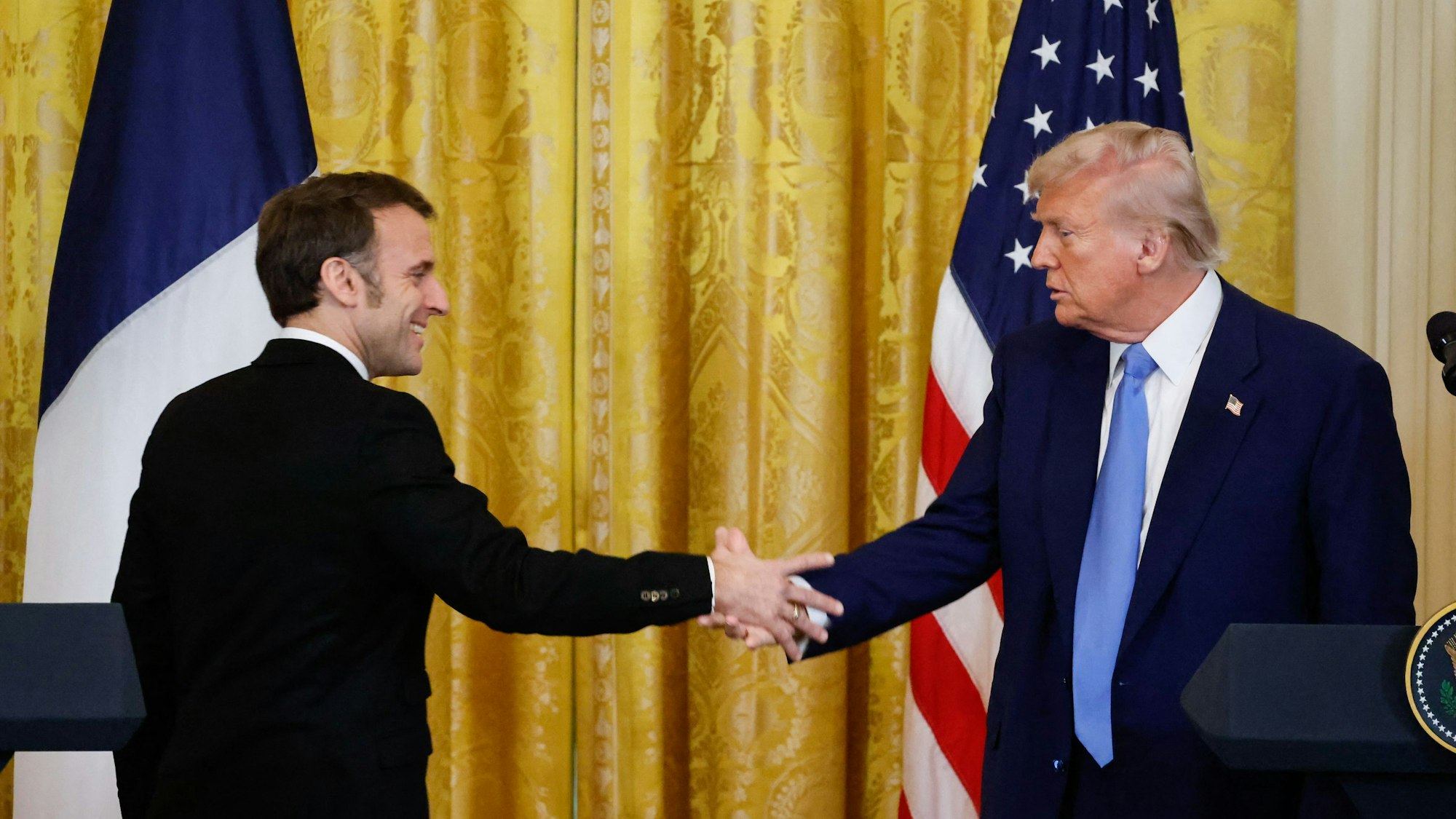 Emmanuel Macron und Donald Trump schütteln sich die Hände.