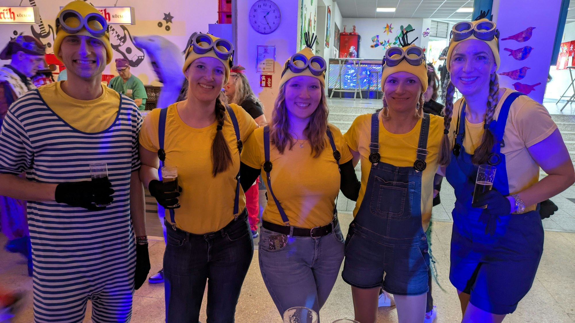 Vier als Minions verkleidete Frauen und ein Mann.