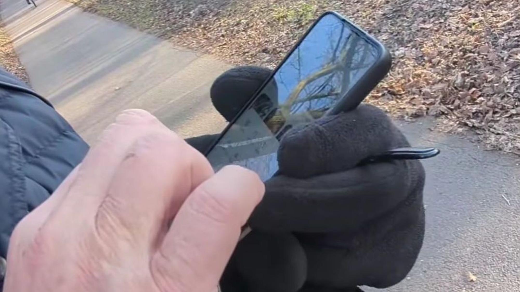 Der Fremde tippt auf seinem Handy, um das Video, das er von Yanni Gentsch gemacht hat, zu löschen.