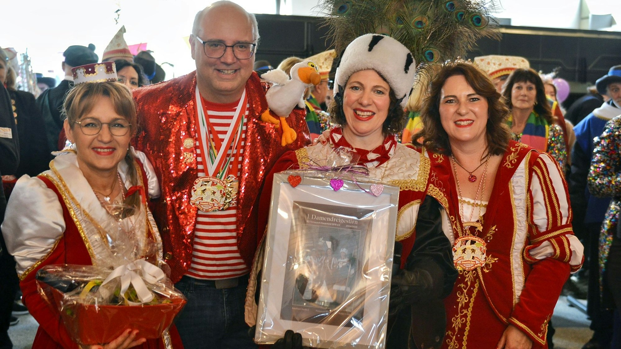 Bürgermeister Jochen Weiler steht in Heimbach inmitten des Damen-Dreigestirns. Die Bäuerin hält ein Bild in die Höhe, die Jungfrau einen Präsentkorb.