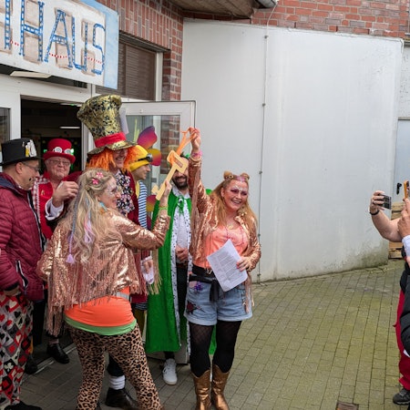 Karnevalistinnen in Burscheid halten triumphierend einen Pappschlüssel in die Höhe.