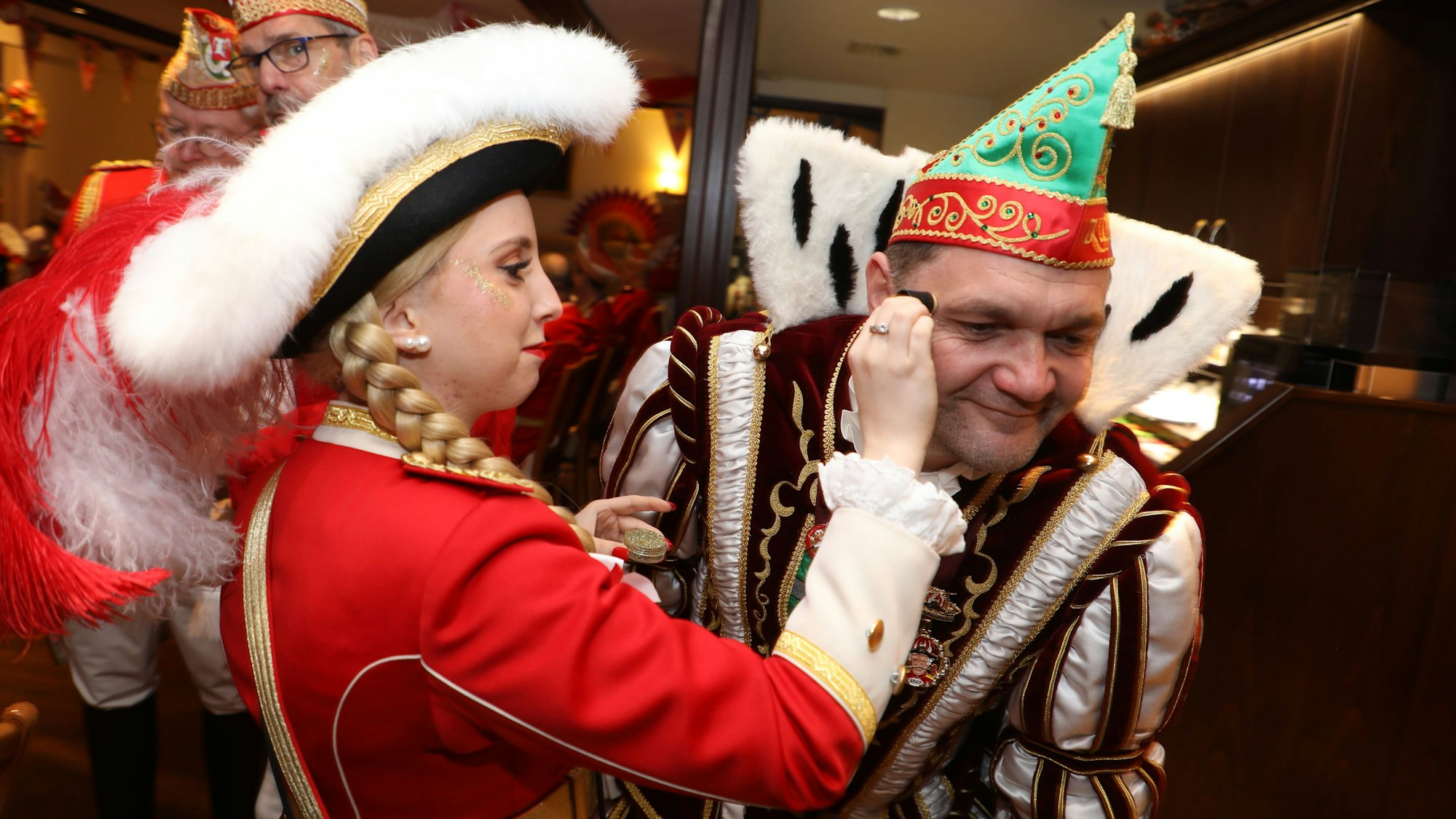 Tanzmarie Leonie Bochnig verteilt Glitzer im Gesicht von Prinz Christian I.