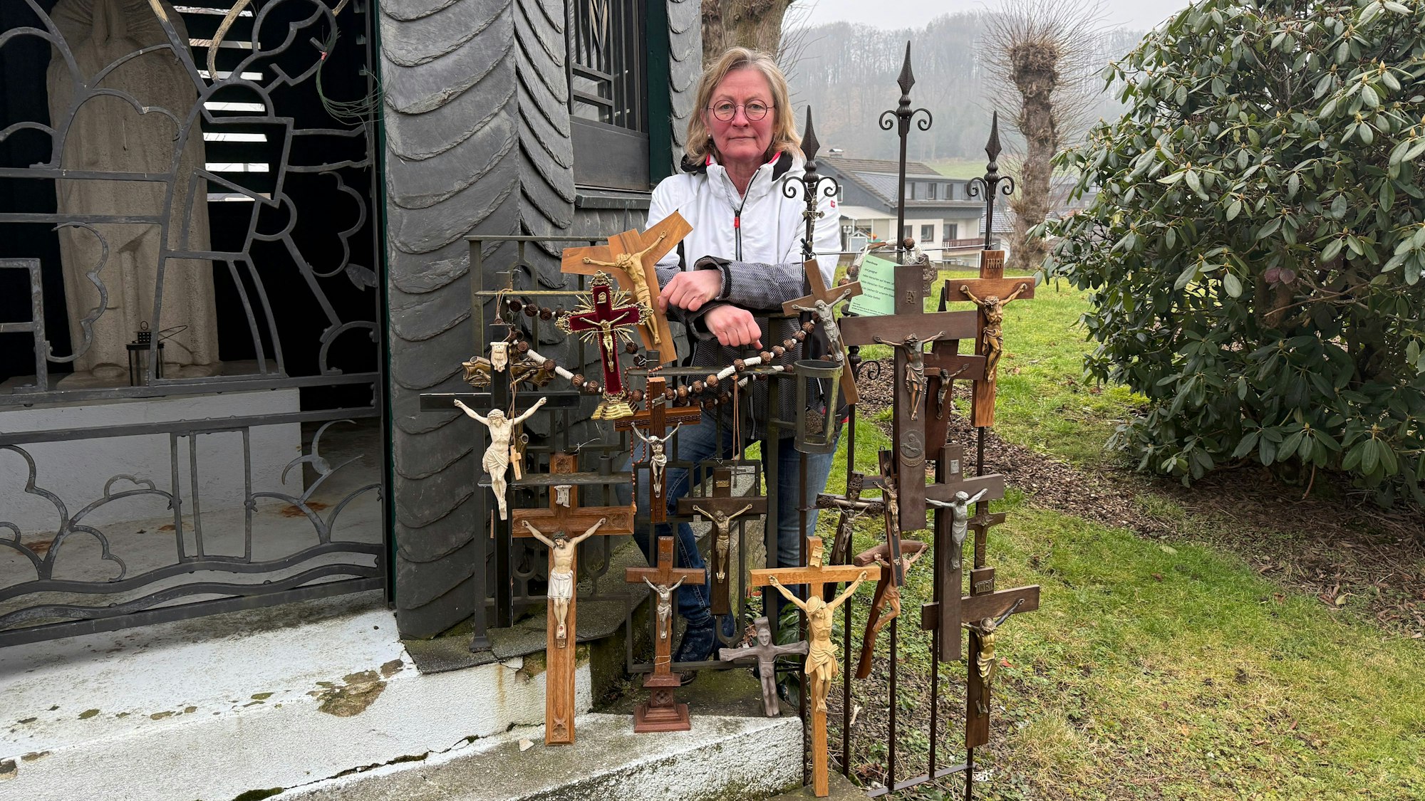 Gemeindereferentin Gudrun Schmitz zeigt die gesammelten Kruzifixe in Lindlar-Kapellensüng.