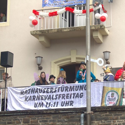 Verkleidete Menschen und Bürgermeisterin Alexandra Gauß stehen auf dem Balkon des Rathauses in Windeck-Rosbach.
