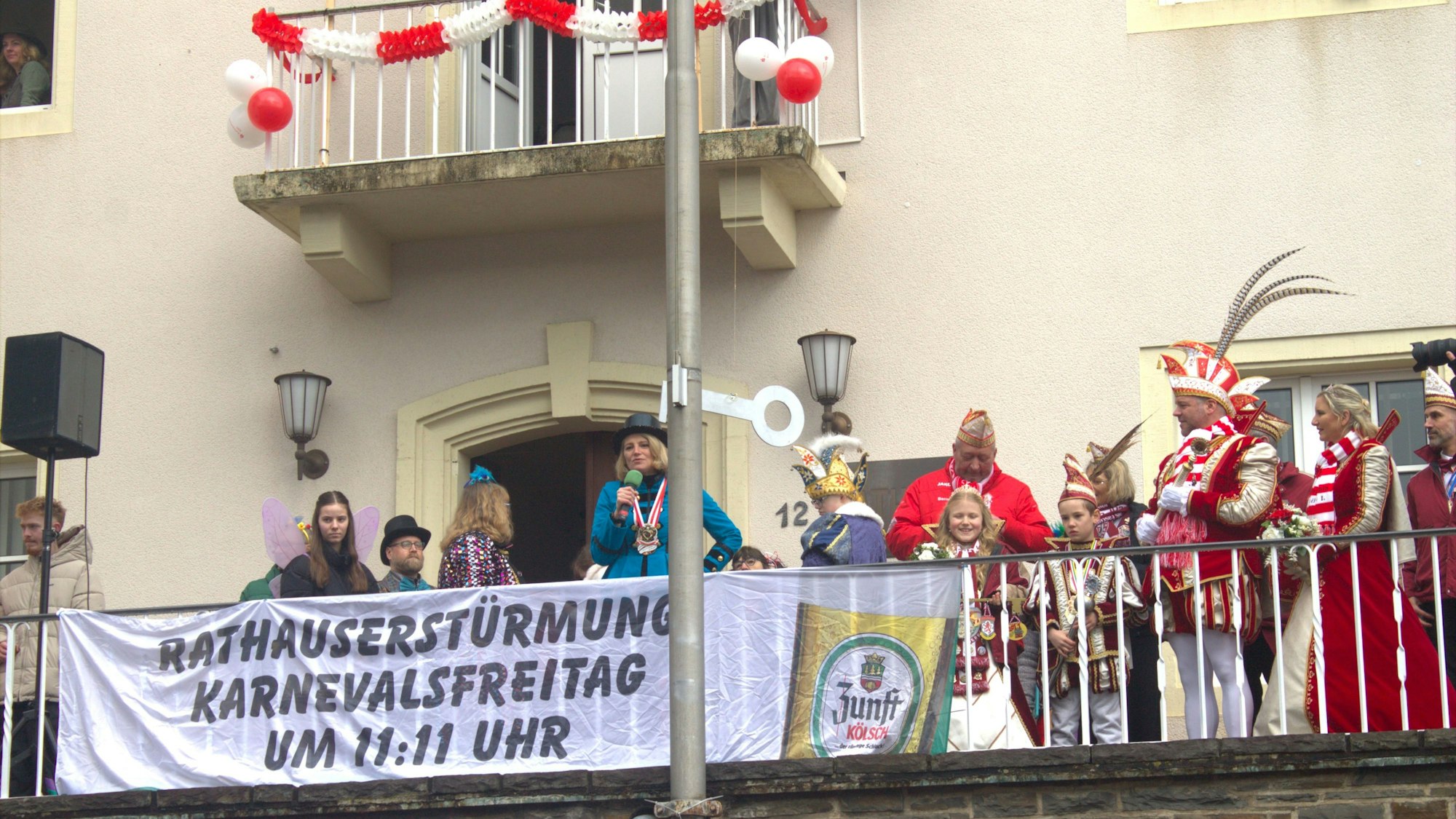 Verkleidete Menschen und Bürgermeisterin Alexandra Gauß stehen auf dem Balkon des Rathauses in Windeck-Rosbach.