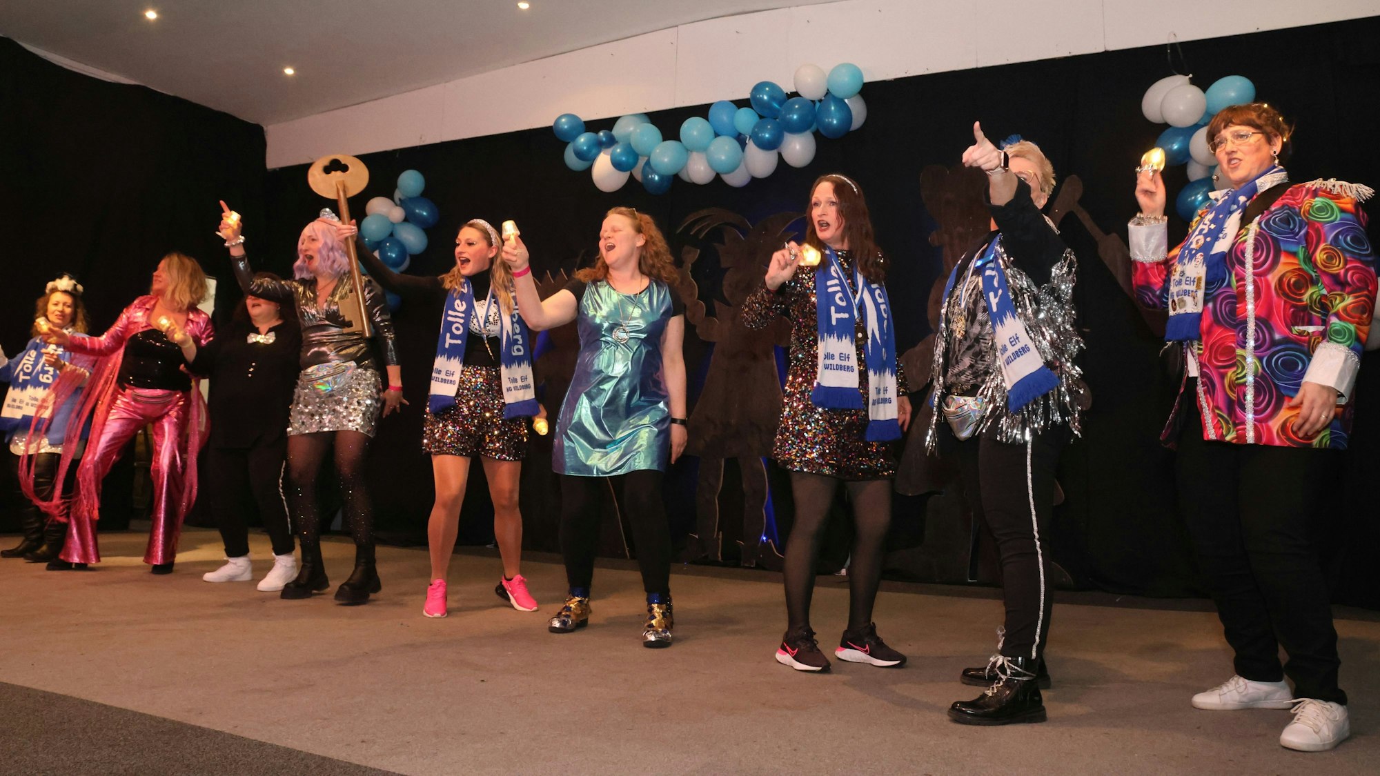 Eine Gruppe steht bei einer Weibersitzung auf der Bühne.