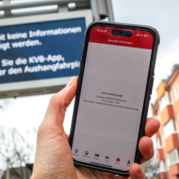 12.02.2025, Köln: Eine Fehlermeldung in der App der Kölner Verkehrsbetriebe (KVB) auf dem Display eines Smartphones sowie eine Störungsmeldung auf einer Anzeige zur Fahrgastinformation sind an einer Haltestelle zu sehen. Umfassende und mehrere Stunden andauernde Probleme beim Internetprovider NetCologne haben zu grossflächigen Störungen geführt. Foto: Matthias Heinekamp