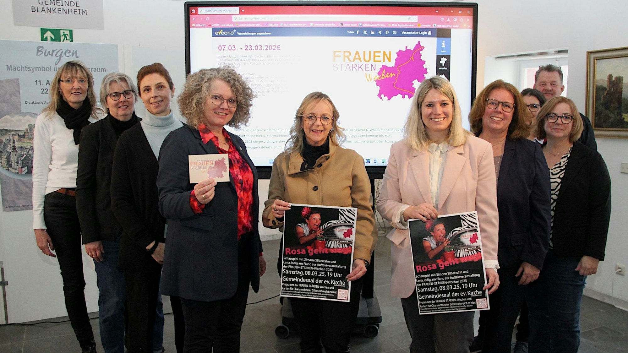 Die Frauen stehen vor dem Plakat der „Frauen-Stärken-Wochen“, die Bürgermeisterinnen halten weiteres Infomaterial in den Händen.