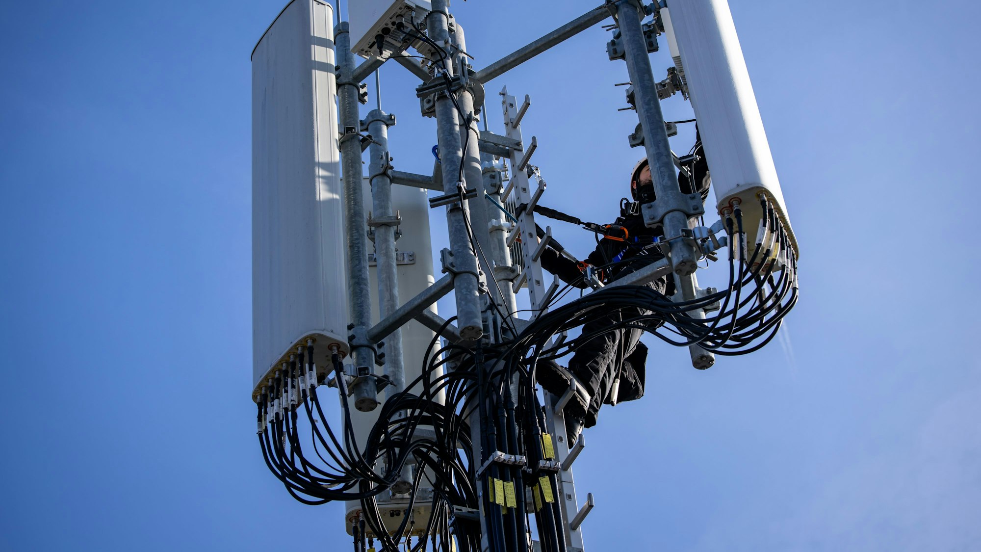 Ein Techniker der Deutschen Telekom führt an einem Mobilfunkmast eine Reparturarbeit an einer aktiven 5G-Antenne (3,6 Ghz) durch.