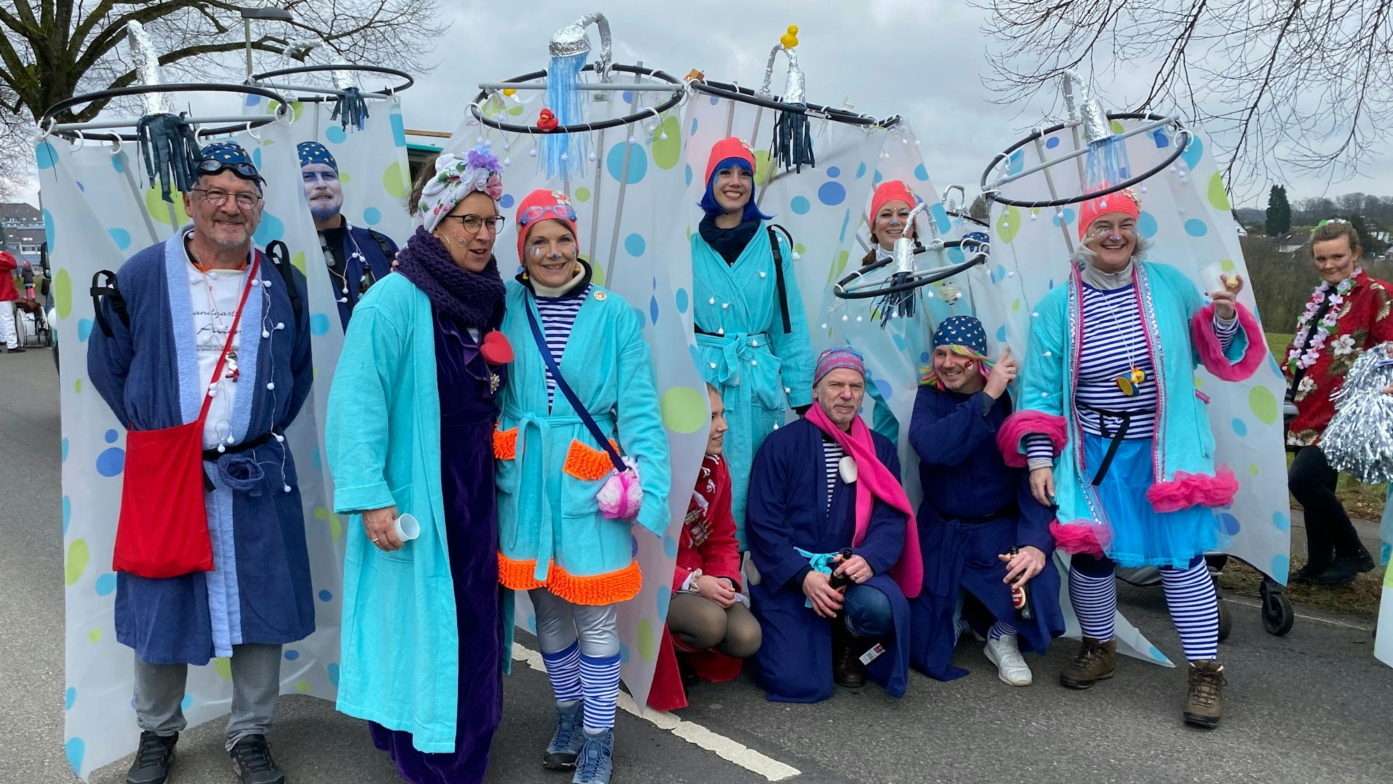 Menschen mit Duschvorhängen stehen in einer Gruppe auf der Straße.