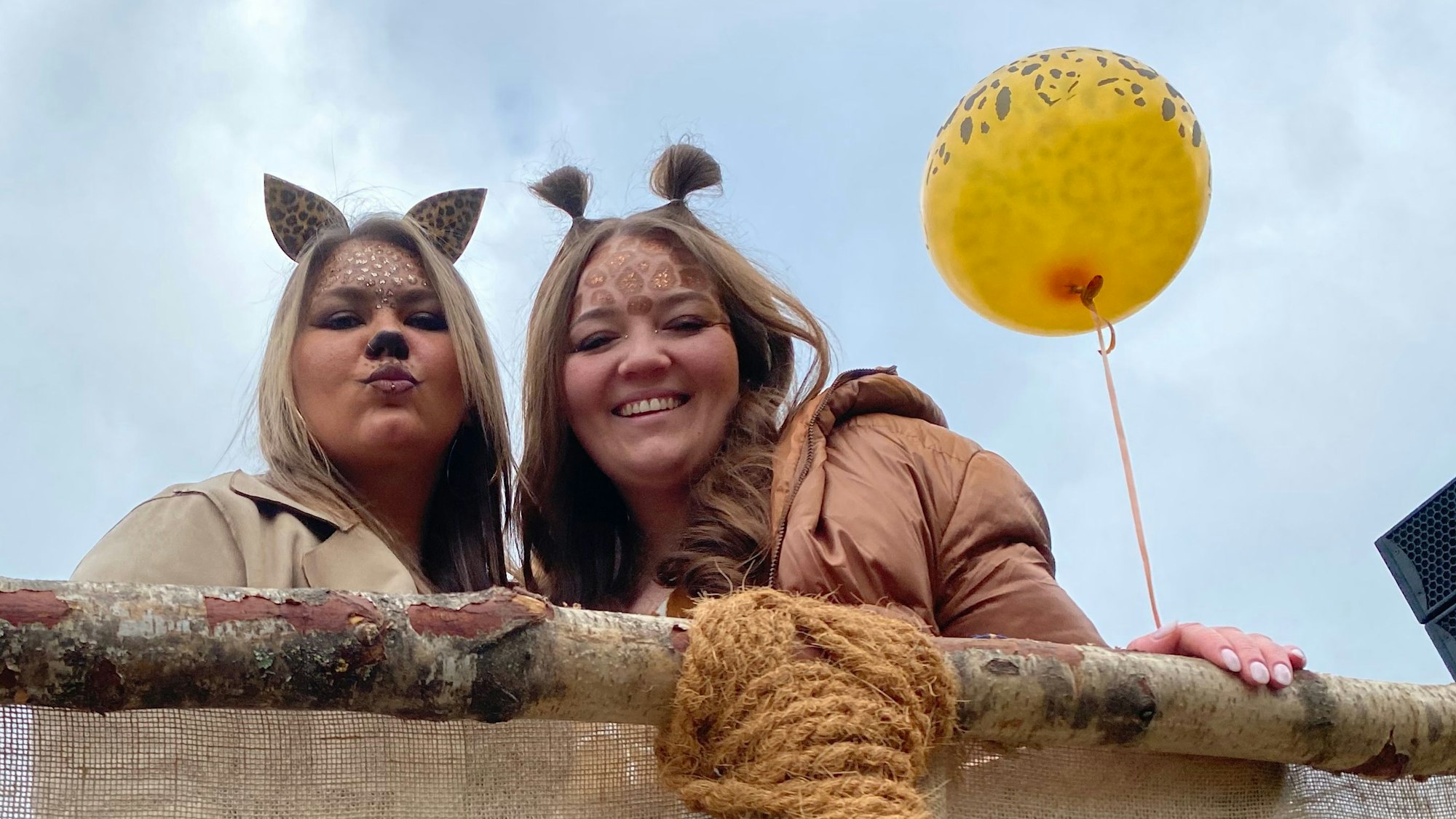 Zwei geschminkte Frauen schauen über ein Geländer.