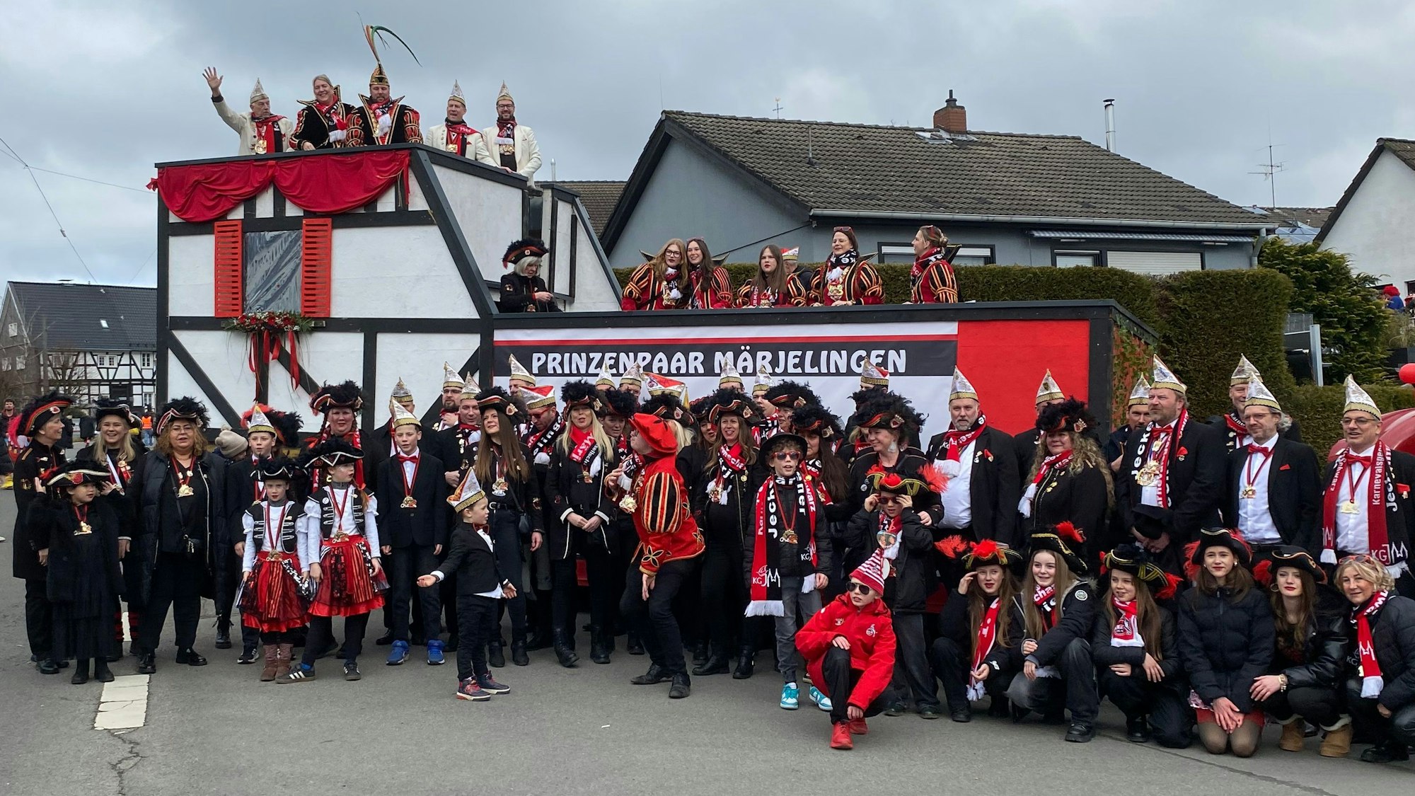 Leute stehen vor und auf einem Karnevalswagen mit der Aufschrift „Prinzenpaar Marialainden“.