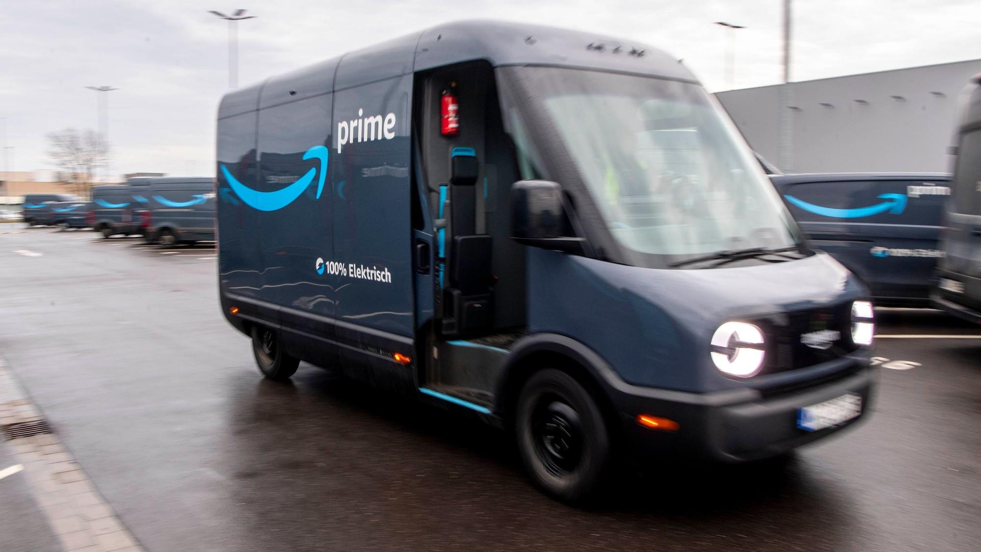 Ein dunkelblauer, elektrisch betriebenes Rivan-Fahrzeug fährt im Amazon-Verteilzentrum in Euskirchen vom Gelände.