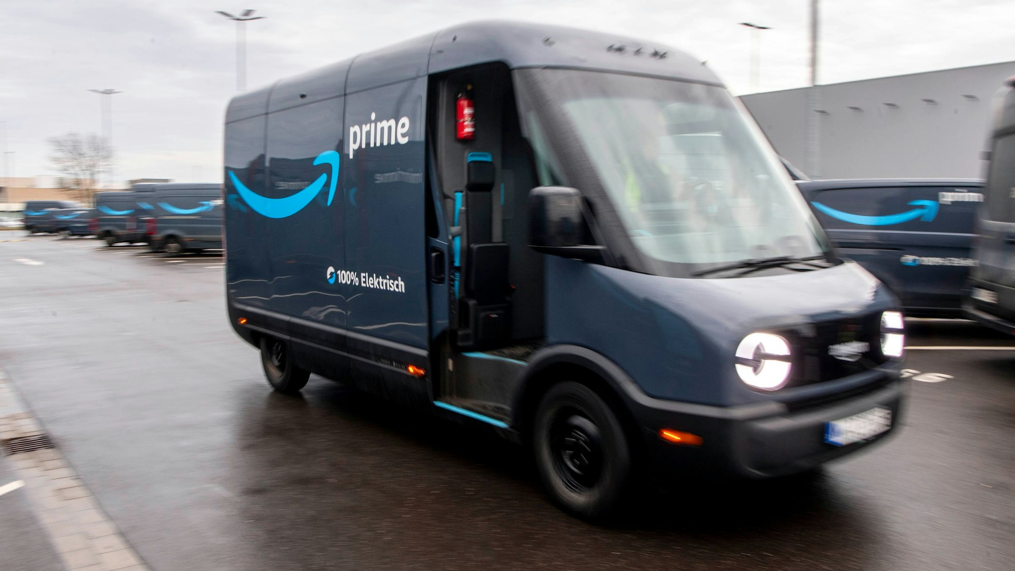 Ein dunkelblauer, elektrisch betriebenes Rivan-Fahrzeug fährt im Amazon-Verteilzentrum in Euskirchen vom Gelände.