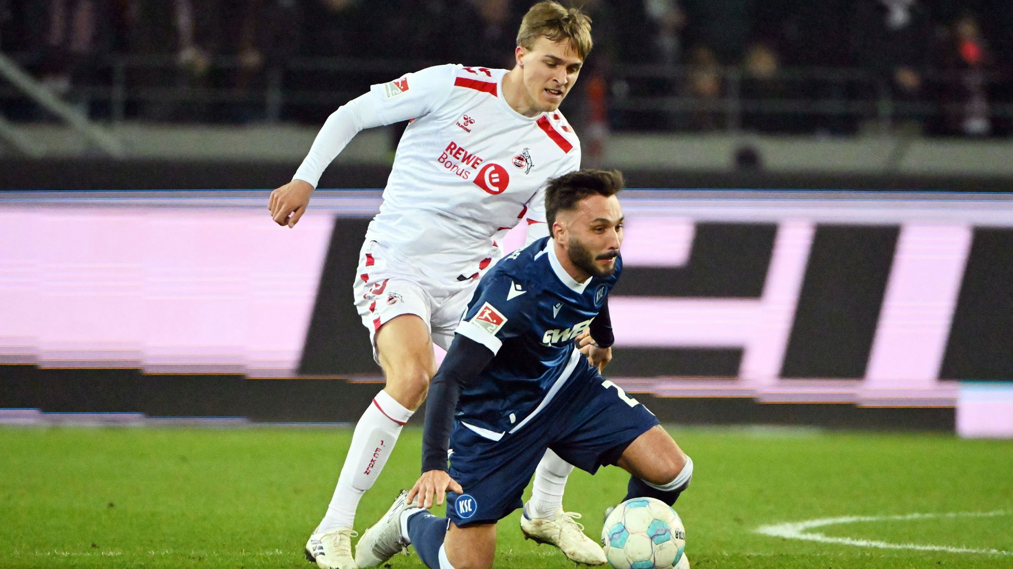 01.03.2025, Baden-Württemberg, Karlsruhe: Fußball: 2. Bundesliga, Karlsruher SC - 1. FC Köln, 24. Spieltag, BBBank Wildpark. Der Karlsruher Fabian Schleusener (r) und der Kölner Timo Hübers kämpfen um den Ball.