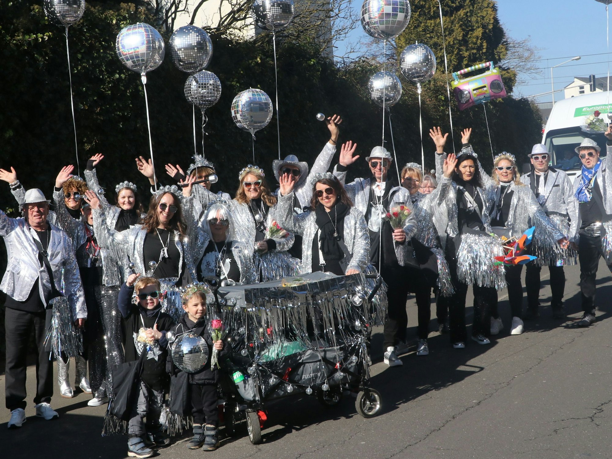 Auf dem Bild ist eine Fußgruppe zu sehen, die sich als Discokugeln verkleidet haben.