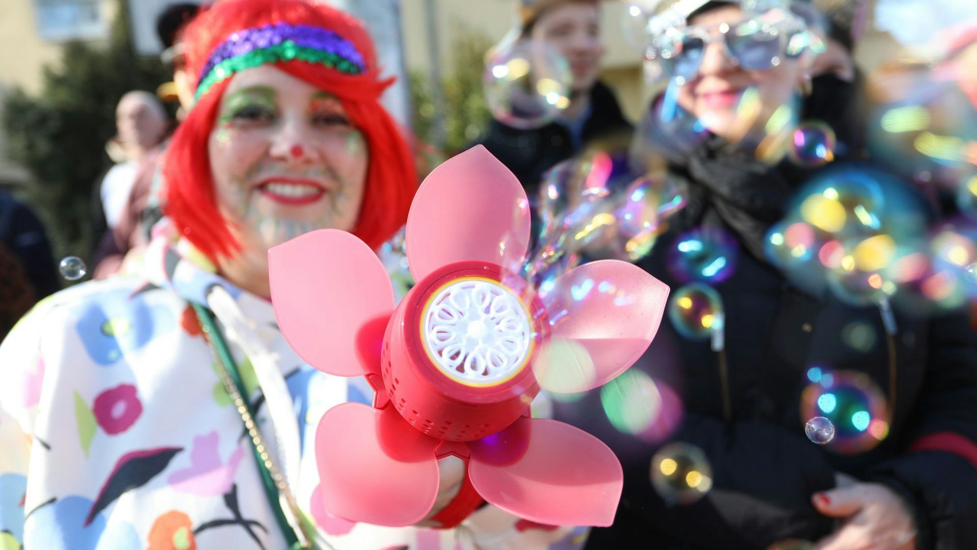 Eine bunt verkleidete Frau sorgt für Seifenblasen.