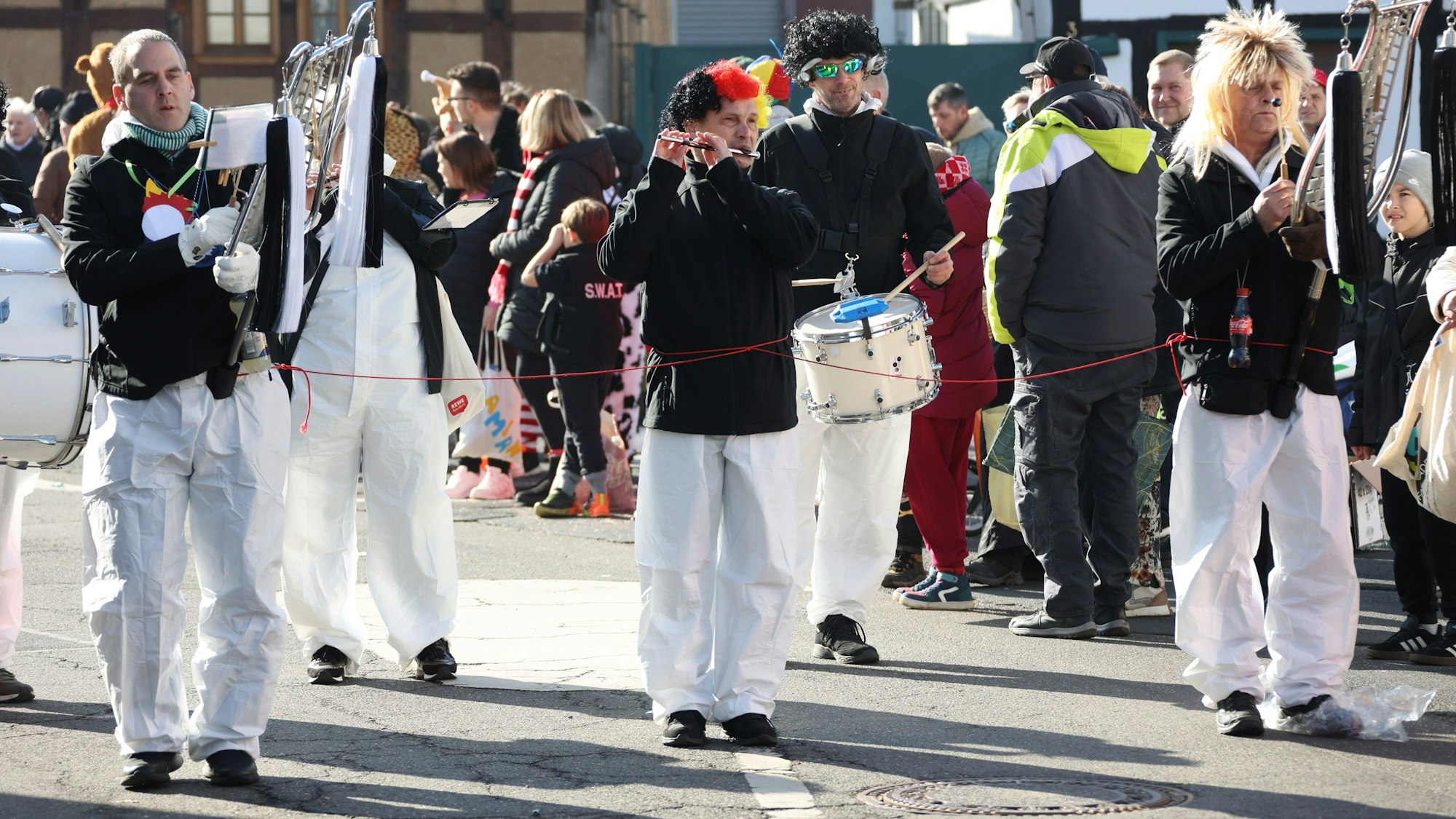 Zwei Musiker vom Tambourcorps Kuchenheim nahmen ihren Kollegen mithilfe einer Leine in ihre Mitte. Denn Flötist Micha ist blind. Von seinen Mitspielern erhielt er so die Zeichen, wann gehen und wann stehenbleiben angesagt ist.