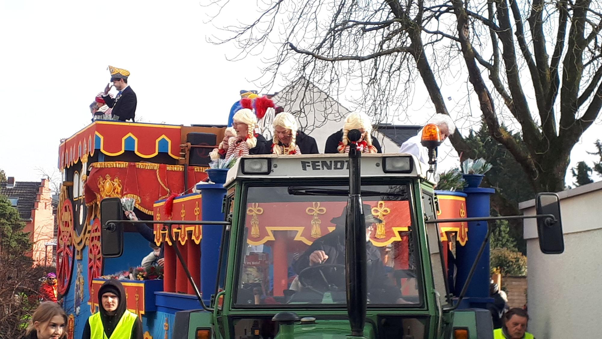 Ein Festwagen ist zu sehen, der von einem Traktor gezogen wird.
