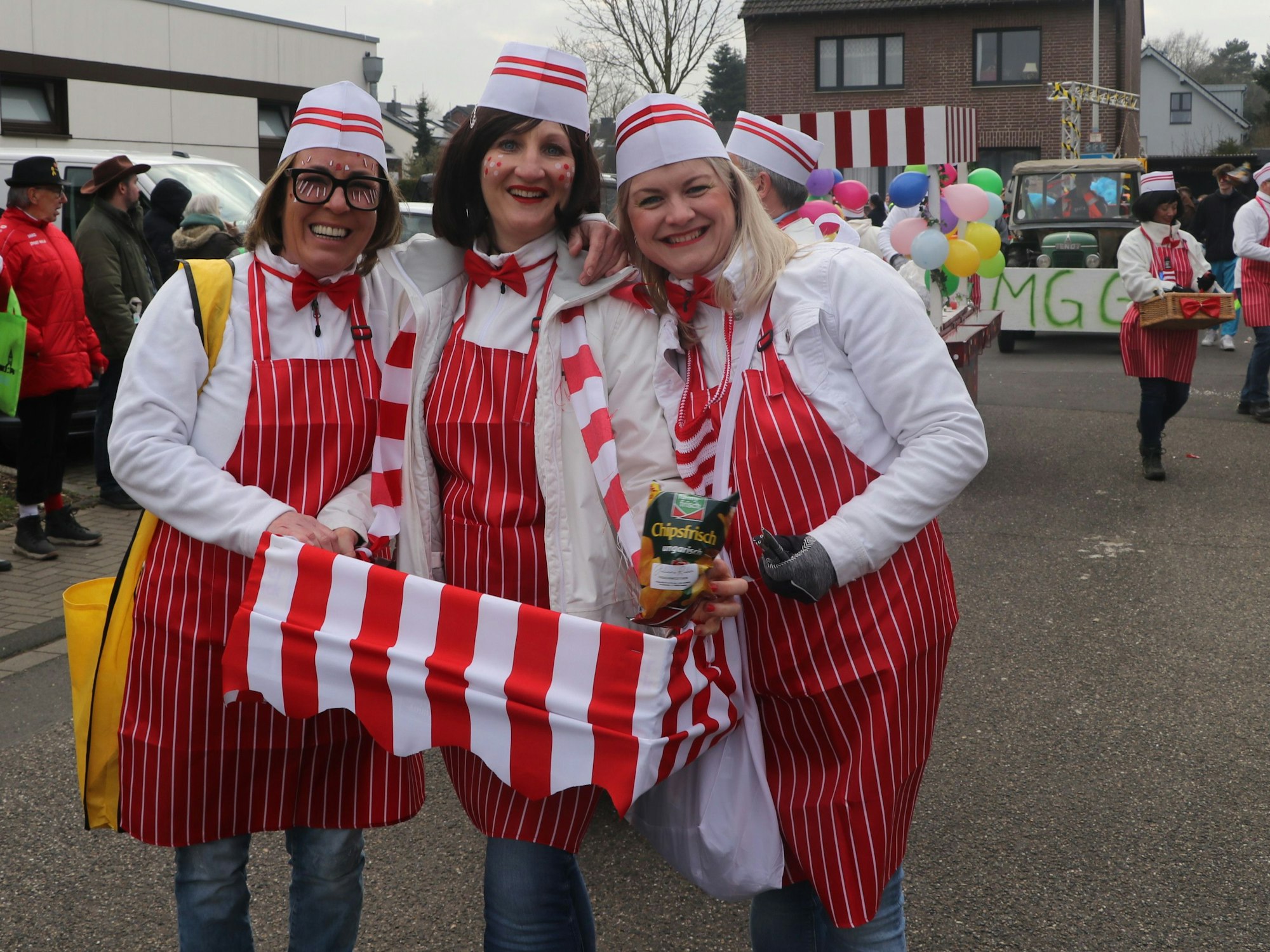 Auf dem Bild sind drei Frauen in einem rot-weißen Kostüm zu sehen.