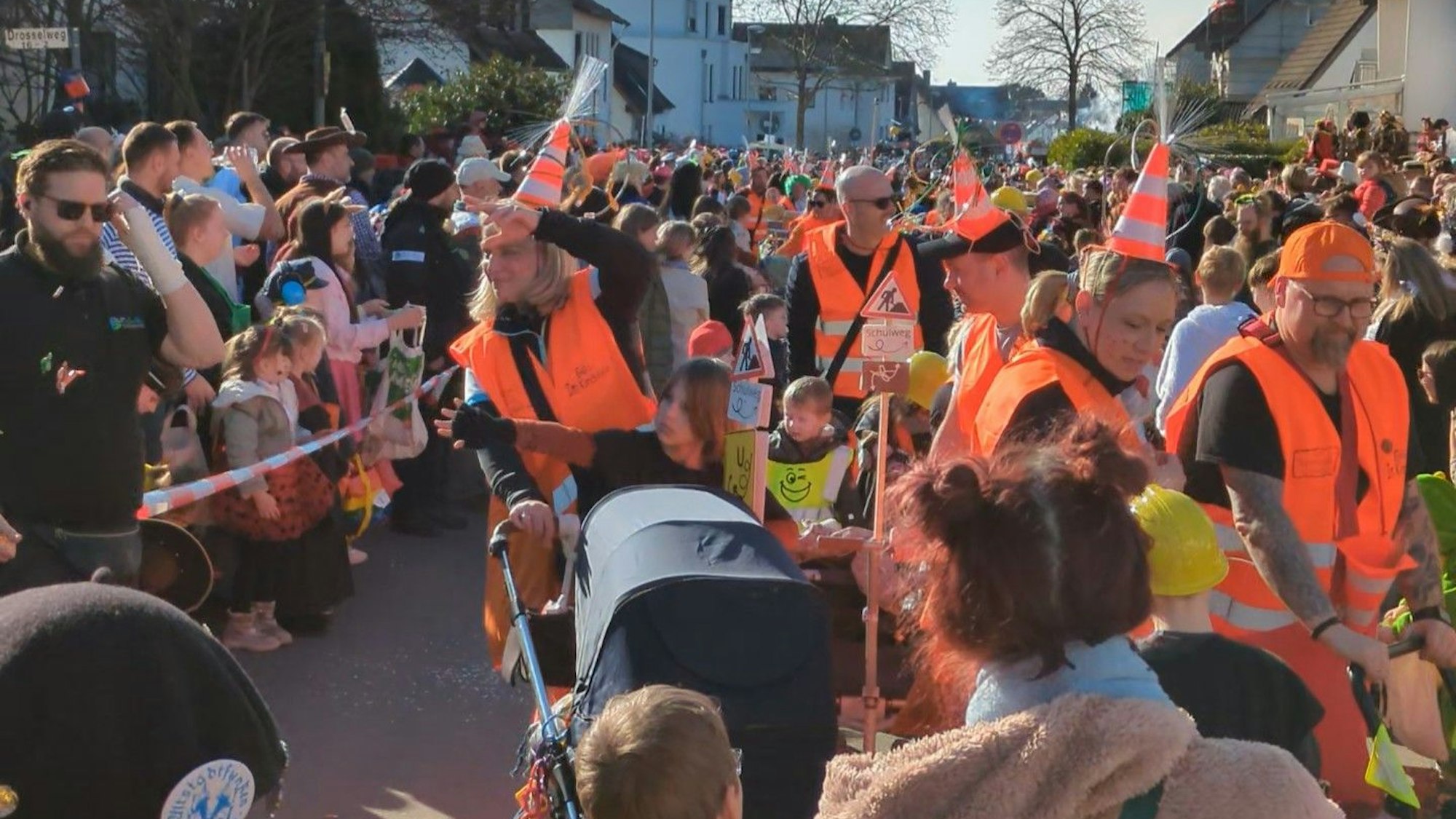 Als Bauarbeiter verkleidete Karnevalisten werfen Kamelle.