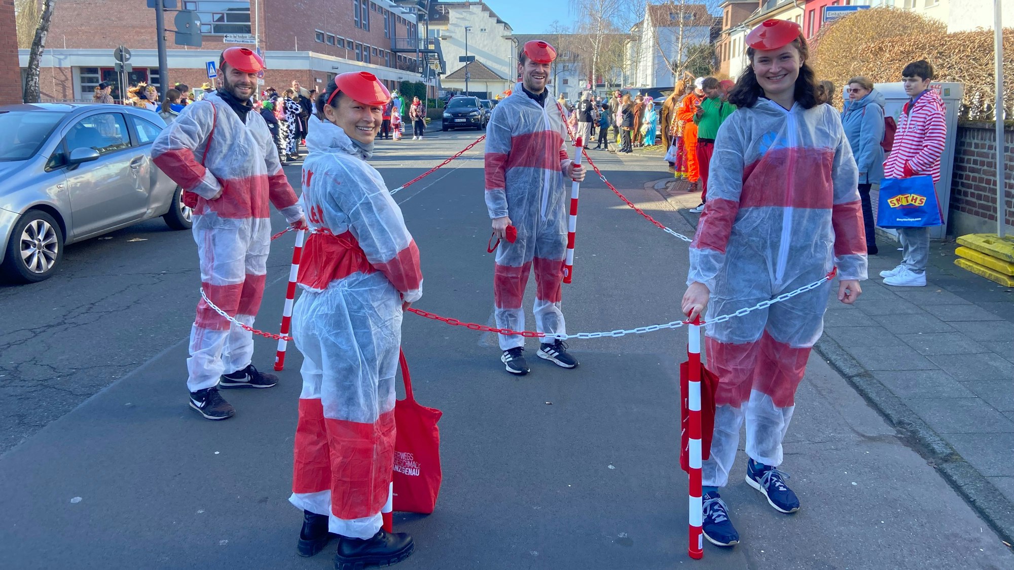 Vier als rot-weiße Poller verkleidete junge Leute sind zu sehen.