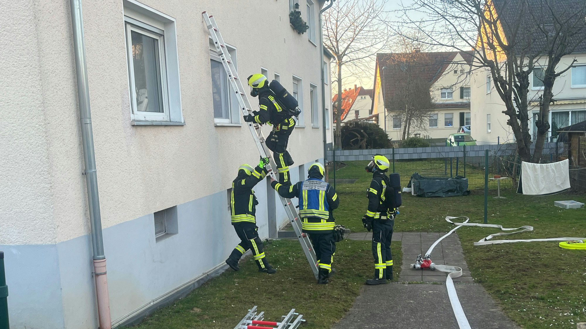 Ein Feuerwehrmann mit Atemschutzgerät klettert auf eine Leiter.