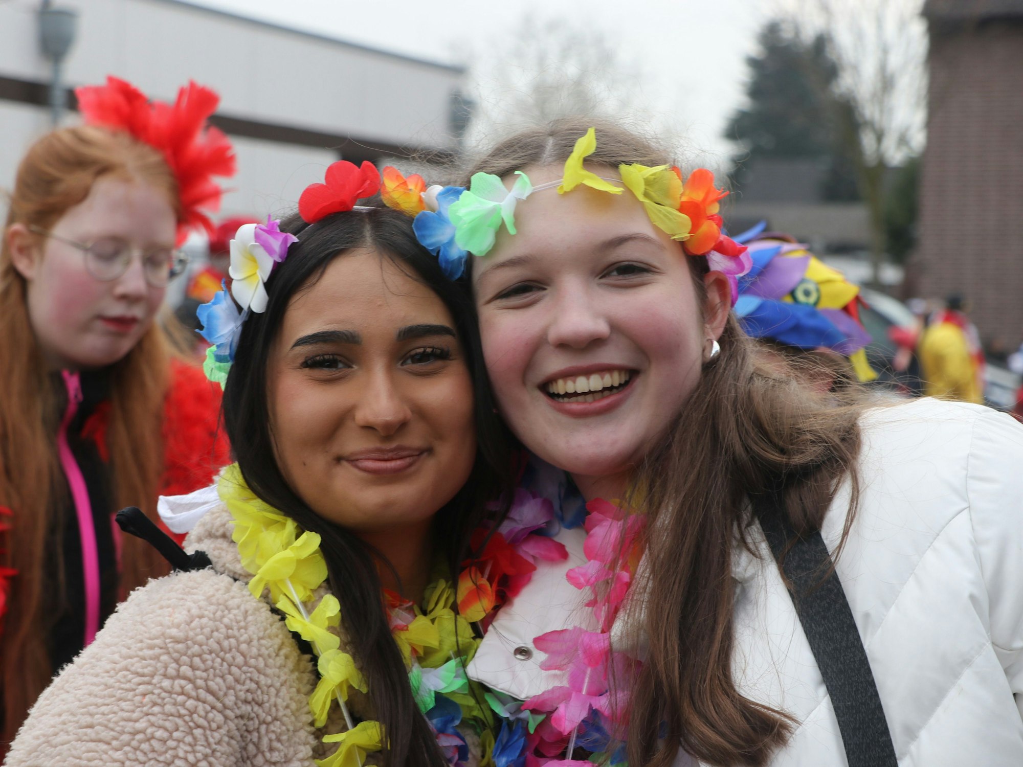 Auf dem Bild sind zwei junge Mädchen zu sehen, die Regenbogen-Girlanden tragen.