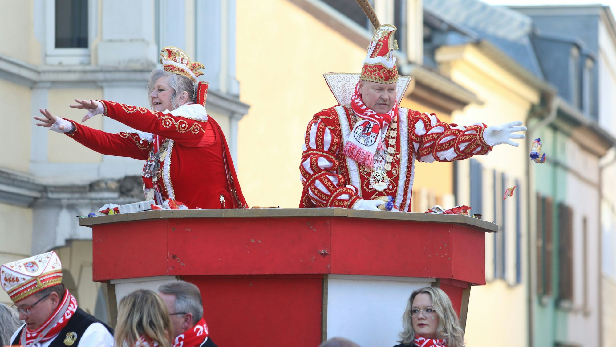 Tollitäten werfen vom Prinzenwagen Kamelle unter die Zuschauer.