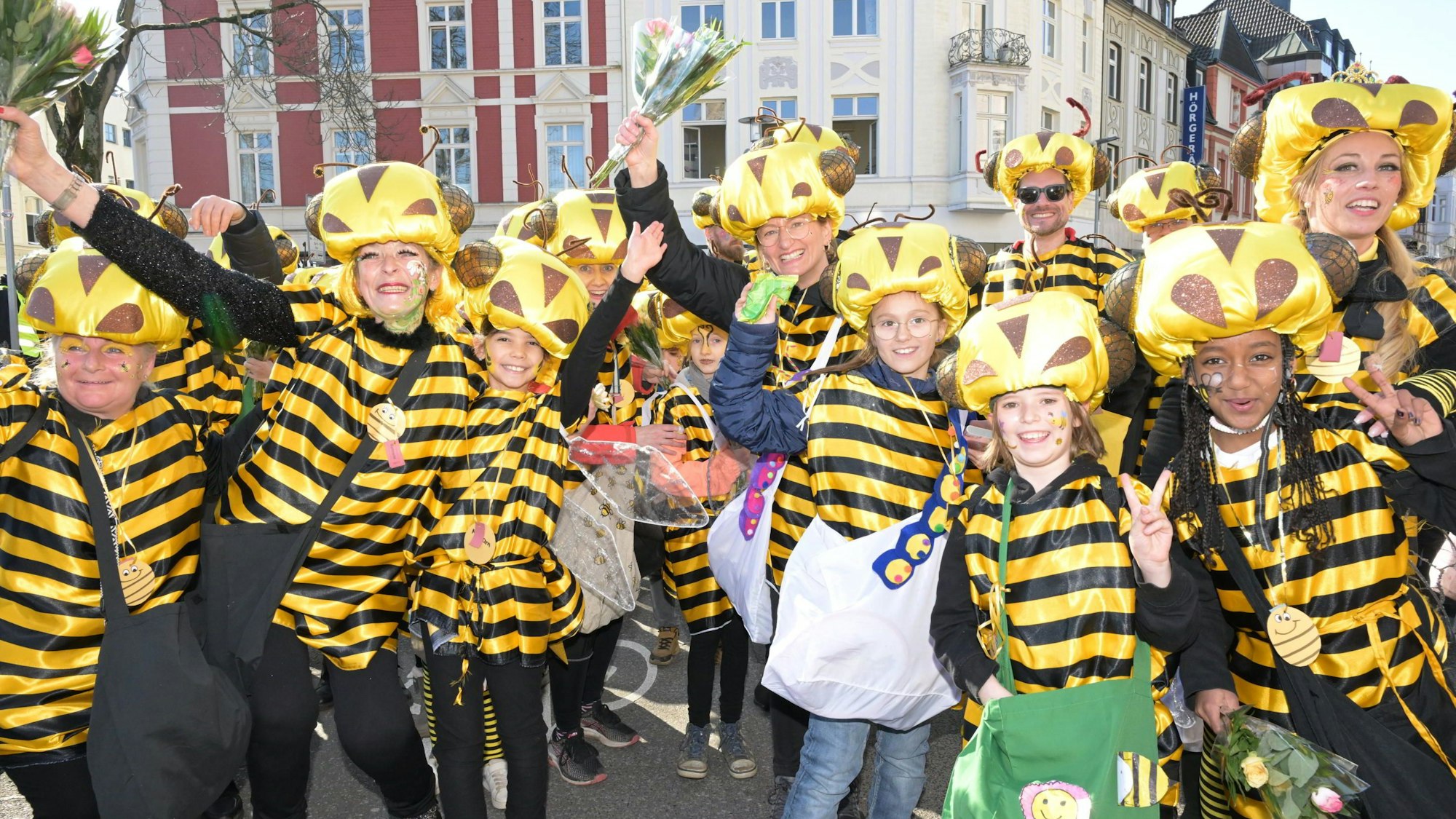 Kinder und Erwachsene in Bienenkostümen stehen auf der Straße im Gladbacher Zoch.