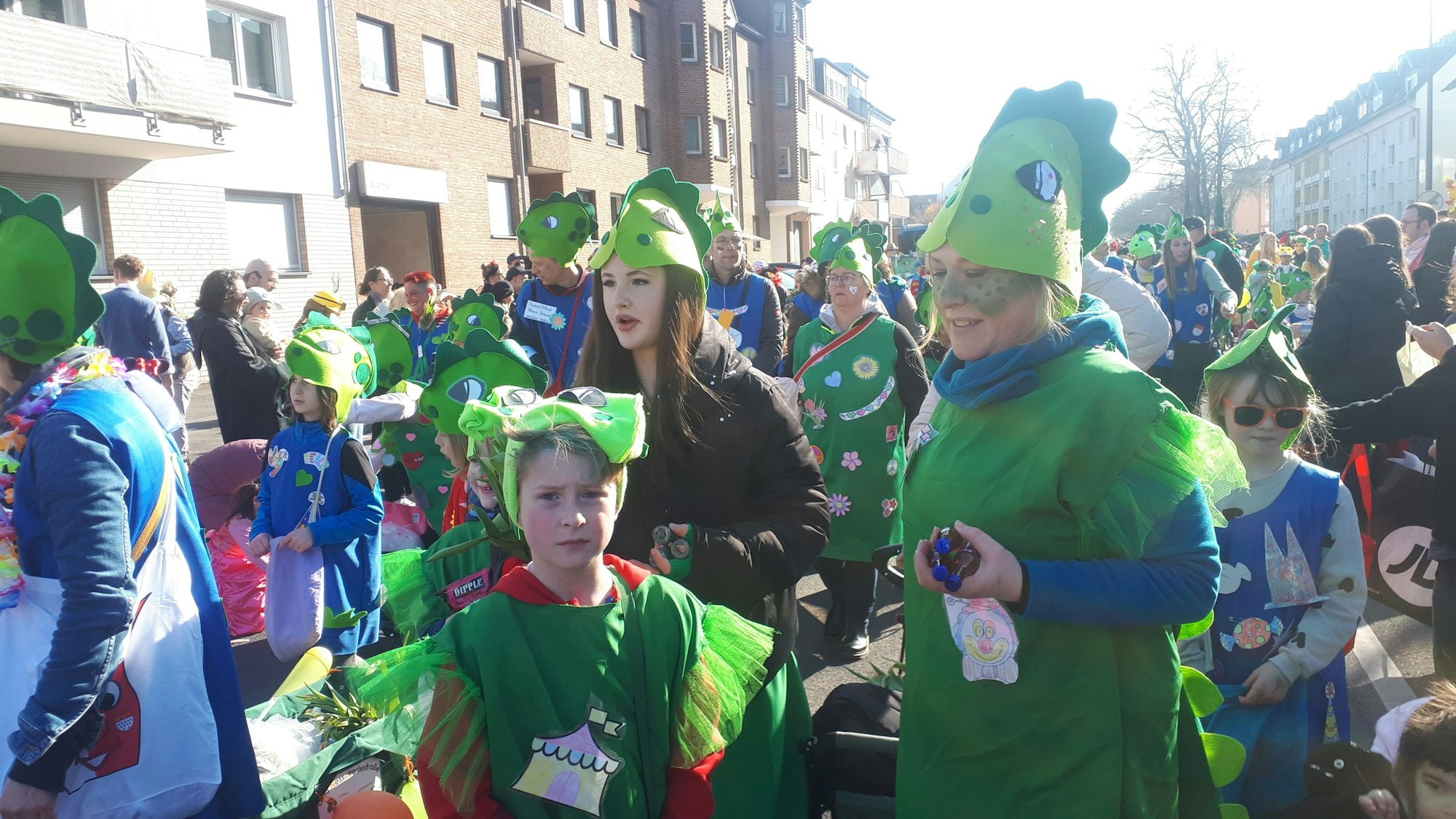 Eine Gruppe in grünen Seeungeheuer-Kostümen läuft durch Niehl.