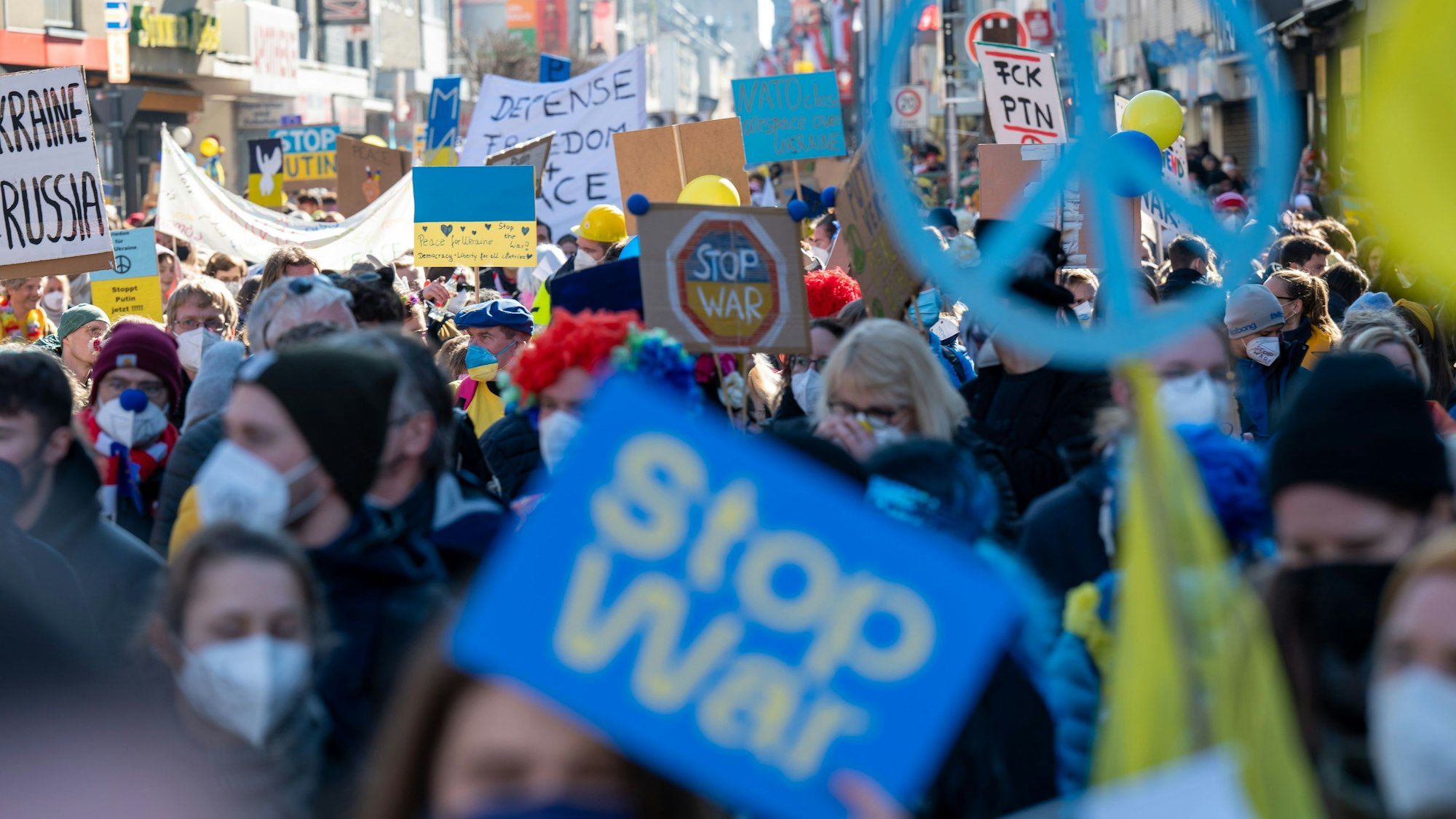28.02.2022, Köln: Demonstranten mit Plakaten Friedensdemo des Festkomitees auf dem Zugweg des Rosenmontagszugs. Protest gegen den Krieg Russlands gegen die Ukraine. Foto: Uwe Weiser