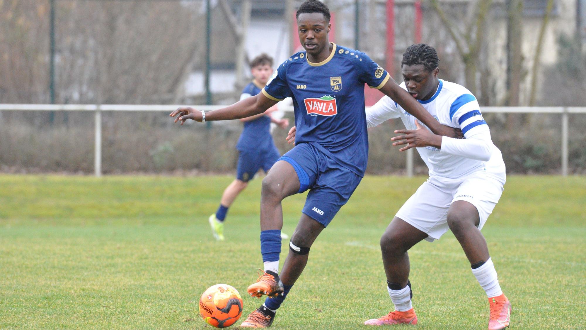 Das Foto zeigt einen Fußballer im blauen Trikot, der den Ball vor seinem Königsdorfer Gegenspieler abschirmt.