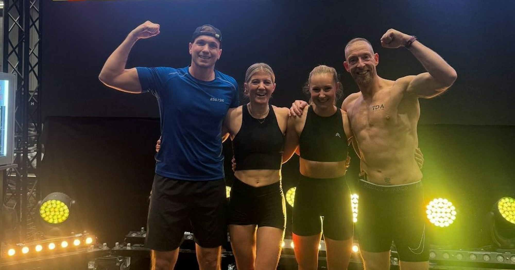 Zwei Männer und zwei Frauen jubeln nach einem Erfolg bei einem Sportwettkampf.
