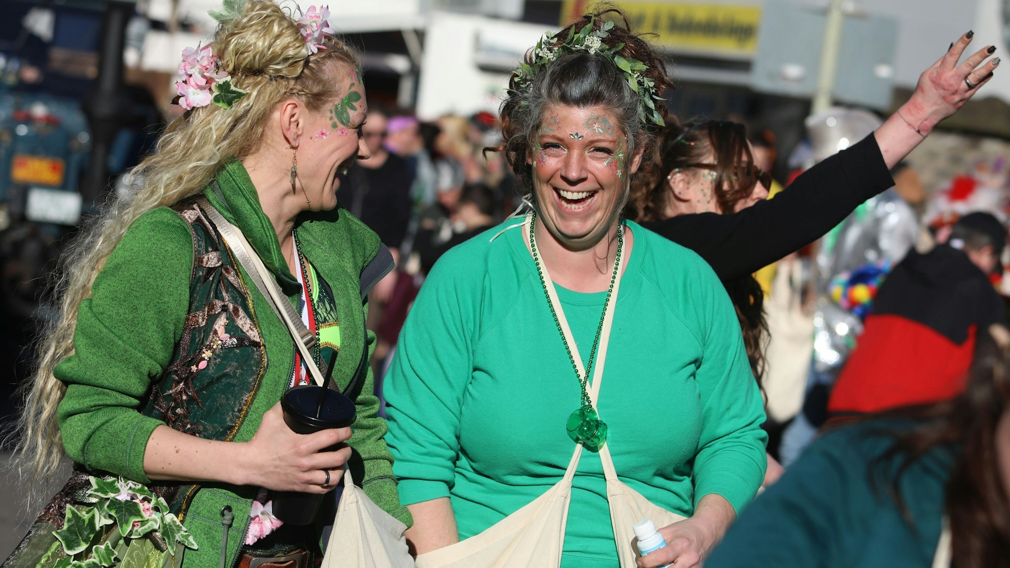 Zwei Teilnehmerinnen des Karnevalszuges mit Blumen und Blättern in den Haaren.