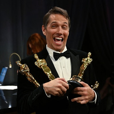 Sean Baker hält vier Oscar-Trophäen in den Händen.