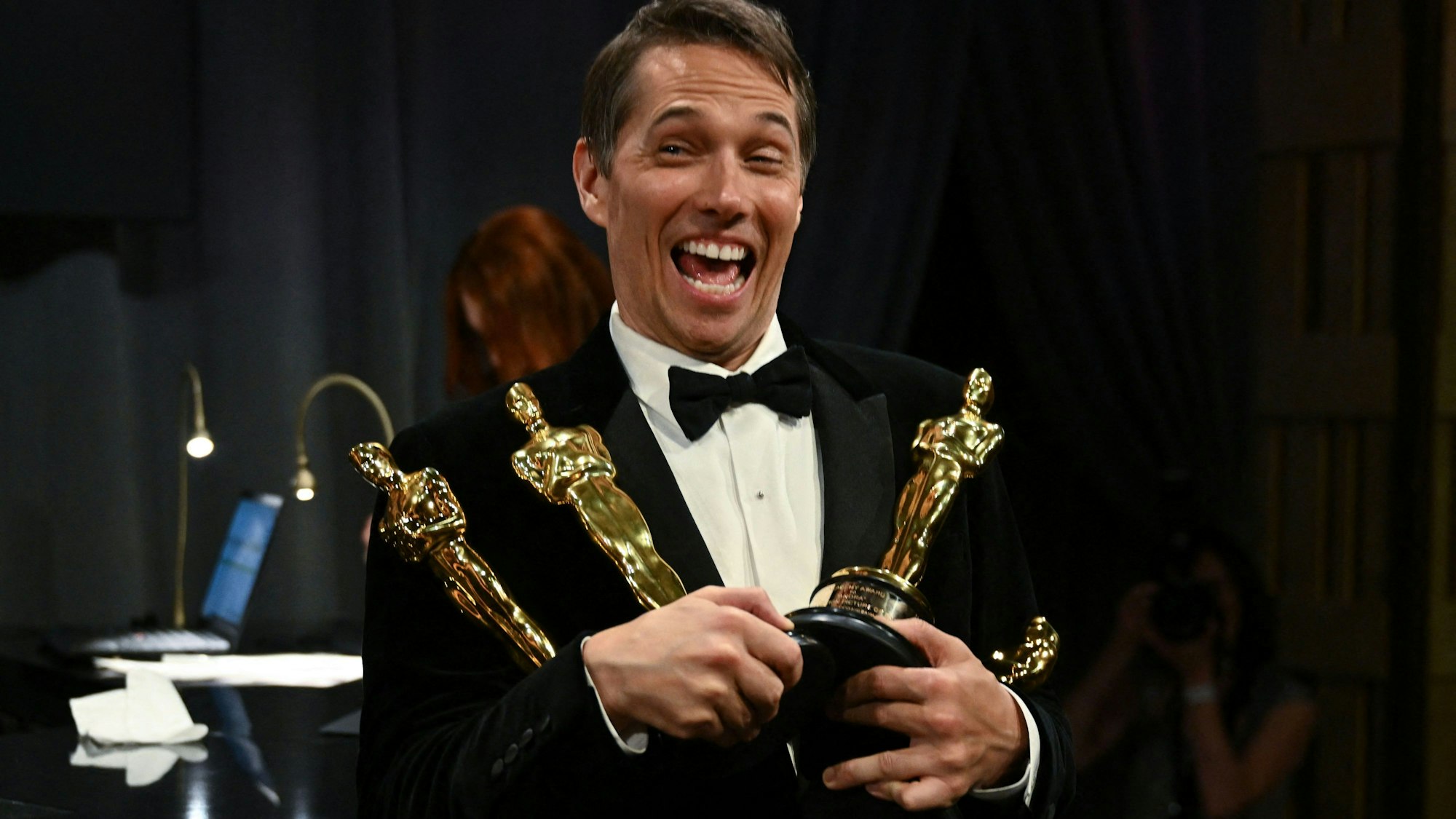 Sean Baker hält vier Oscar-Trophäen in den Händen.