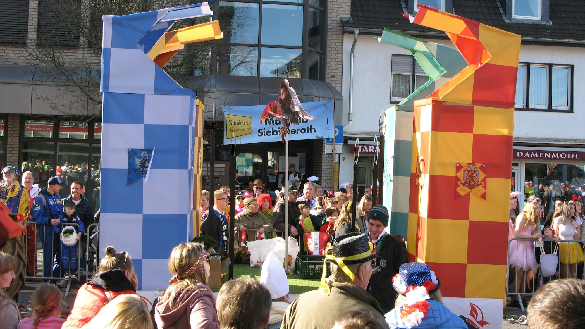 Bild aus dem Karnevalszug mit einem Wagen, auf dem vier bunte Türme stehen.