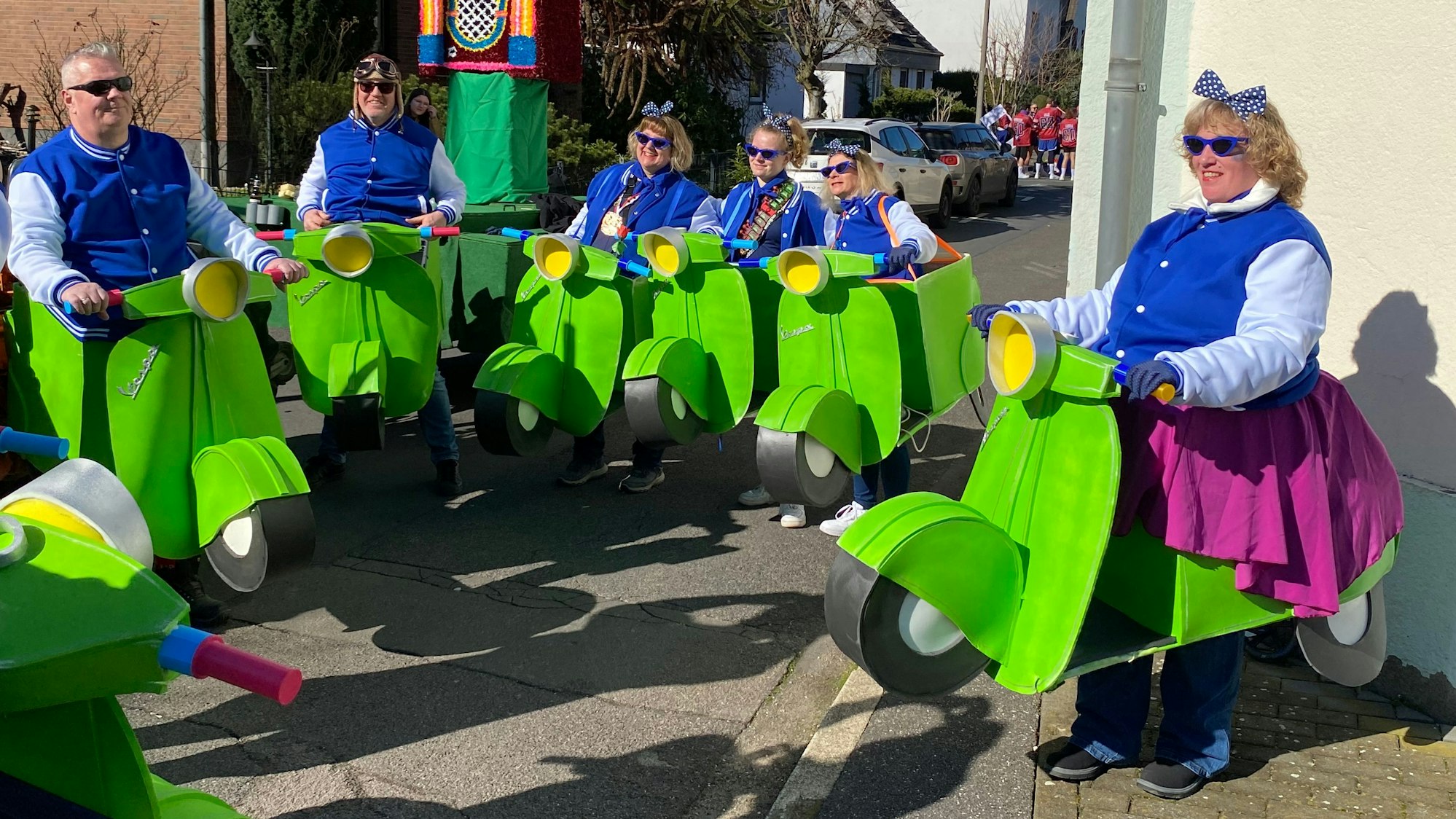 Auf dem Bild ist eine Gruppe zu sehen, die sich Vespa-Kostüme aus Kartons gebaut haben.