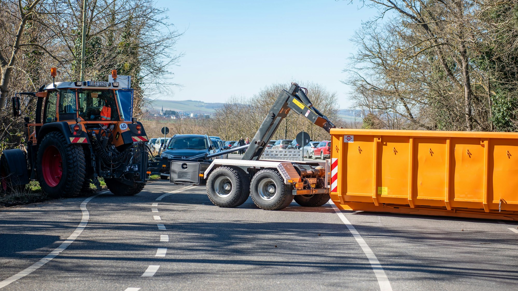 Um den Rosenmontagszug in Zülpich abzusichern, ist eine Straße mit einem Traktor und einem Container abgesperrt.