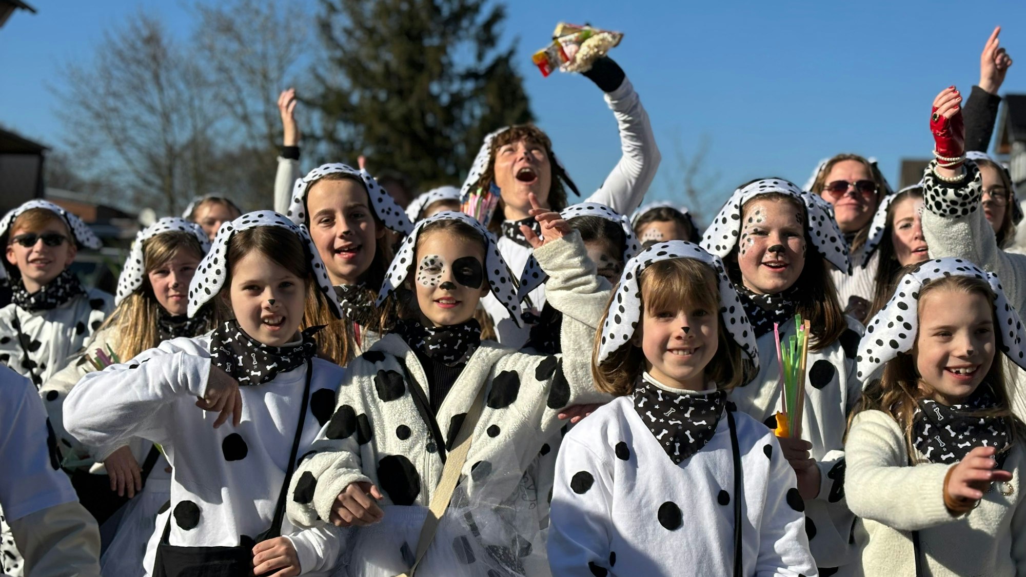 Kinder und Erwachsene in Kuhkostümen freuen sich.